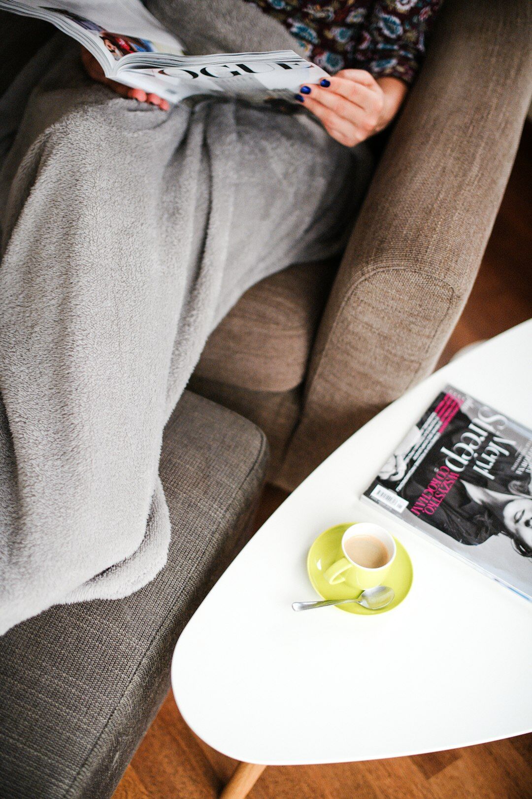 person reading book in armchair
